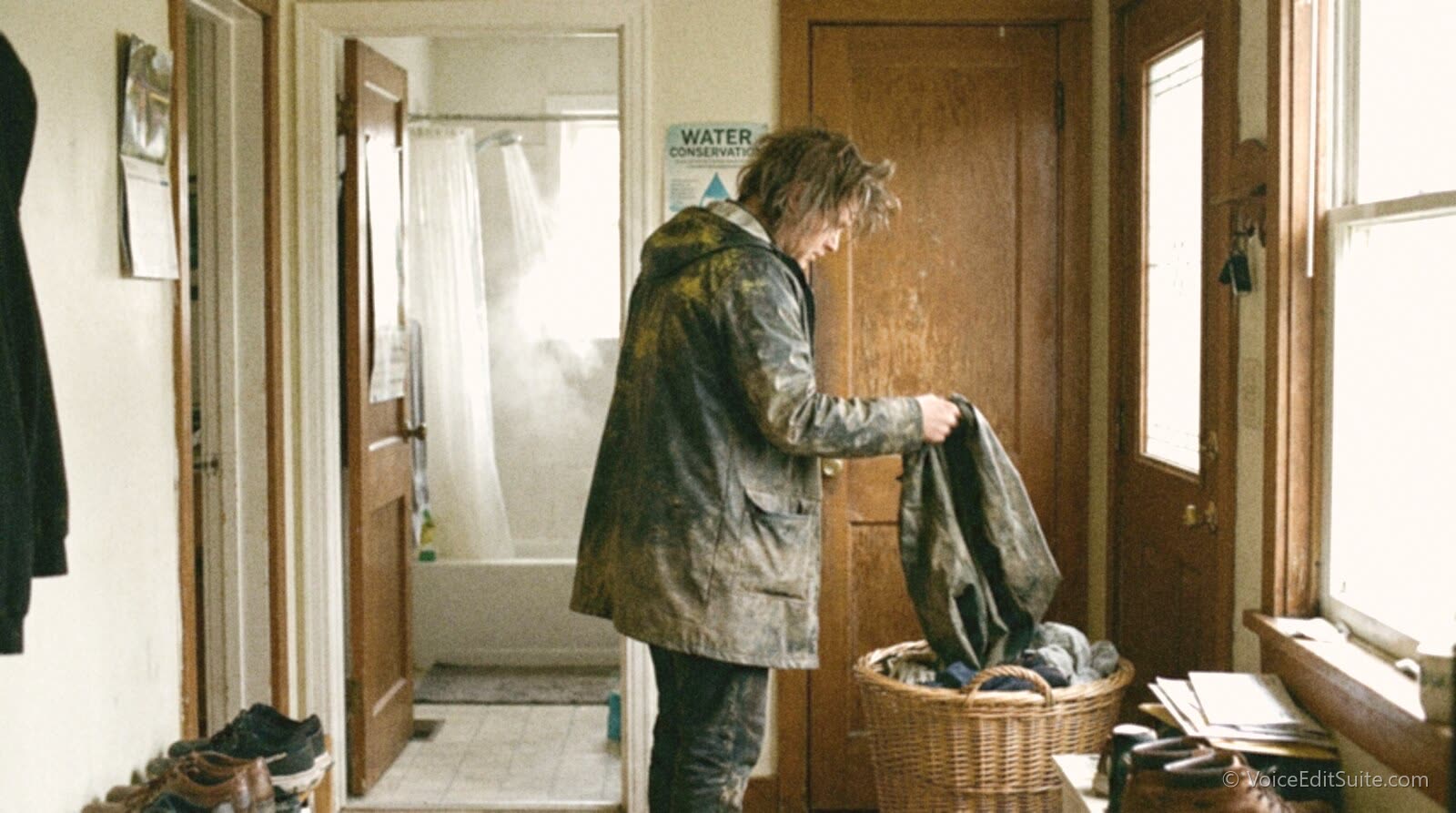 A voice actor dropping a pollen-dusted jacket into a laundry basket after coming in from outside