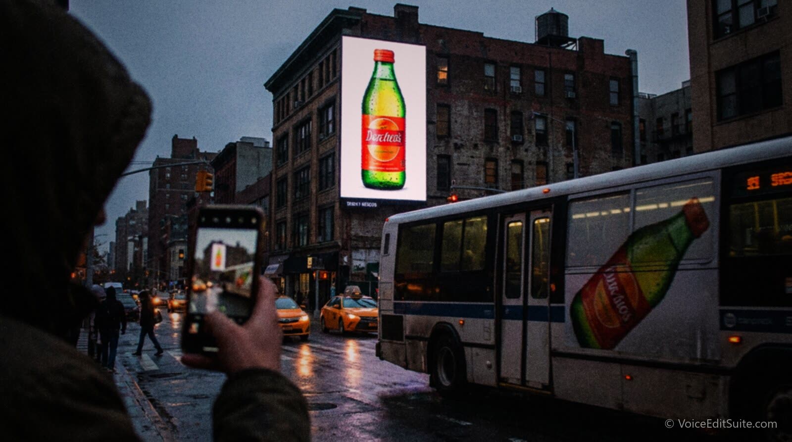 A city street at dusk with the same advertisement on a bus, a billboard and a phone screen