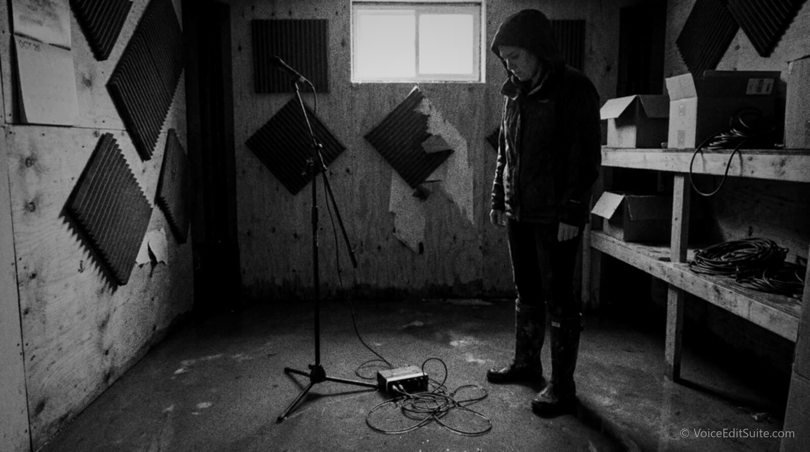 Black and white photograph of a flooded home studio floor with a microphone stand and cables standing in water
